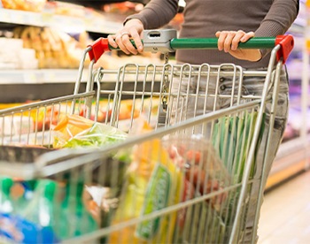 donna spinge carrello del supermercato